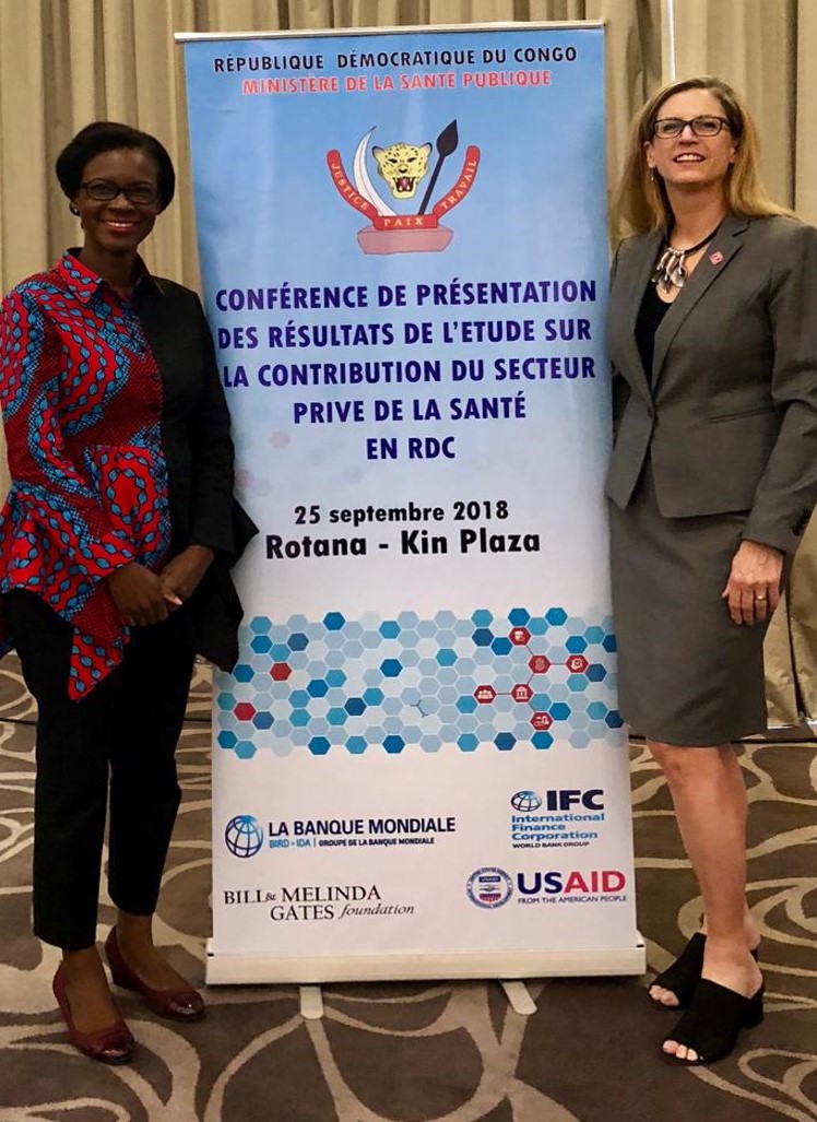 Bettina Burner and World Bank Rep standing next to banner at the event.