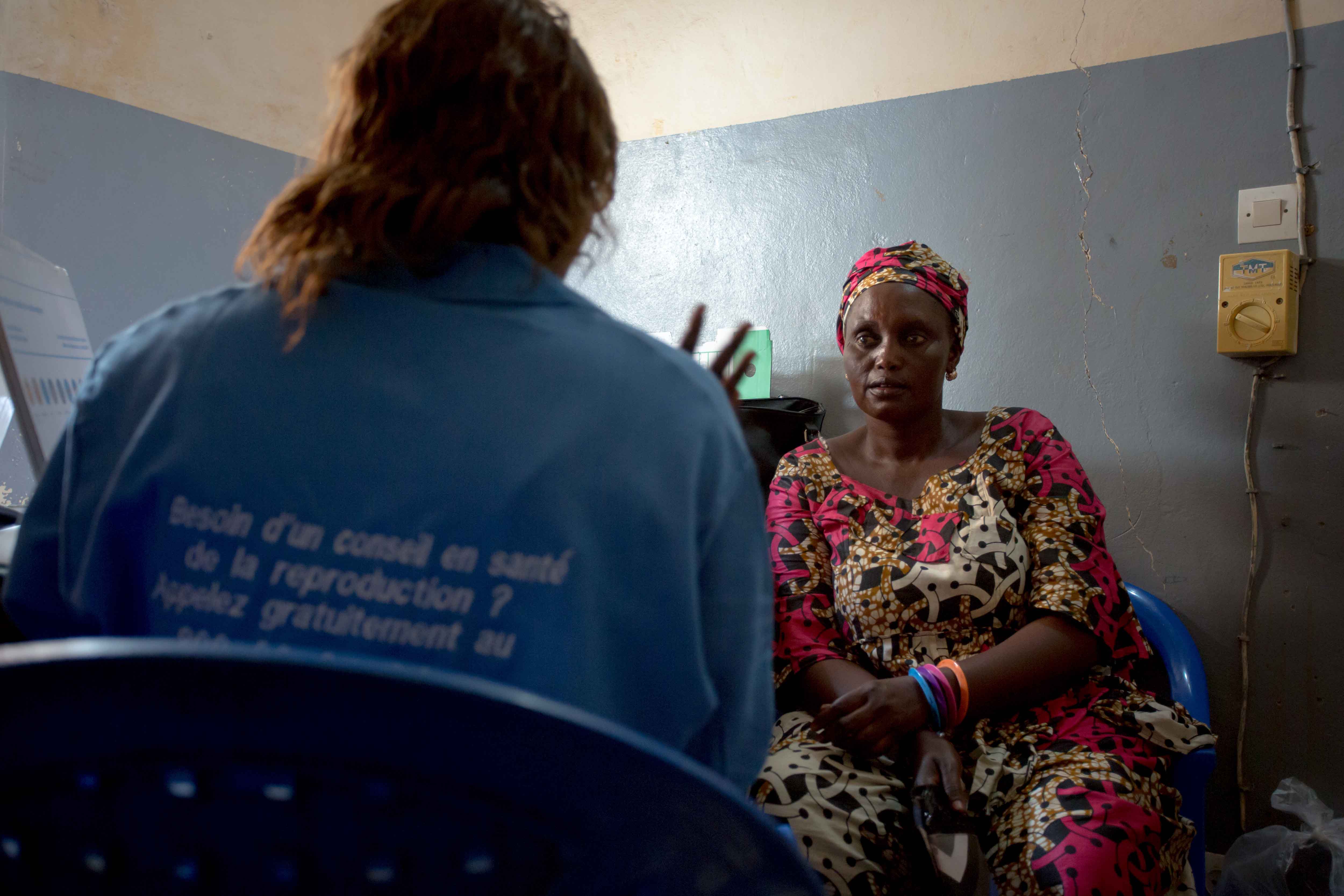Lady in room listening to a health provider talking to her