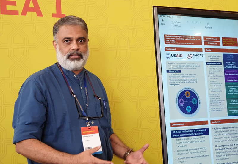 Photo of George presenting a poster at the conference