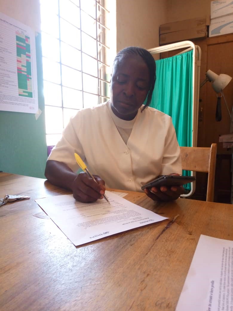 Mary Nyango sitting at a desk doing some work