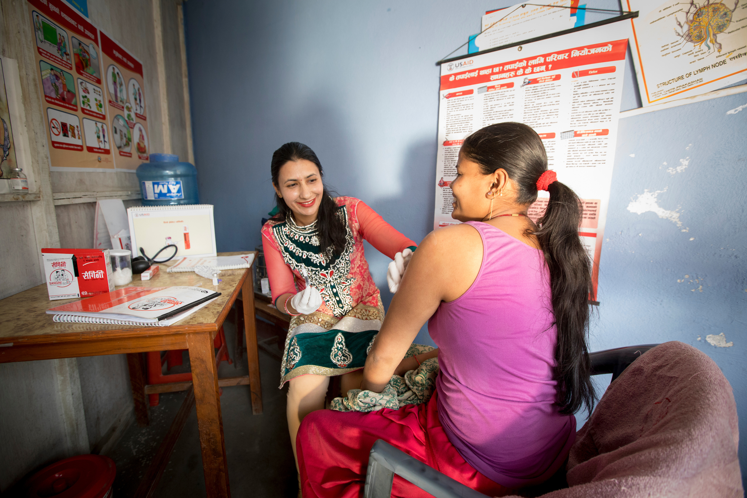 A woman prepares to dispense injectable contraception to a client
