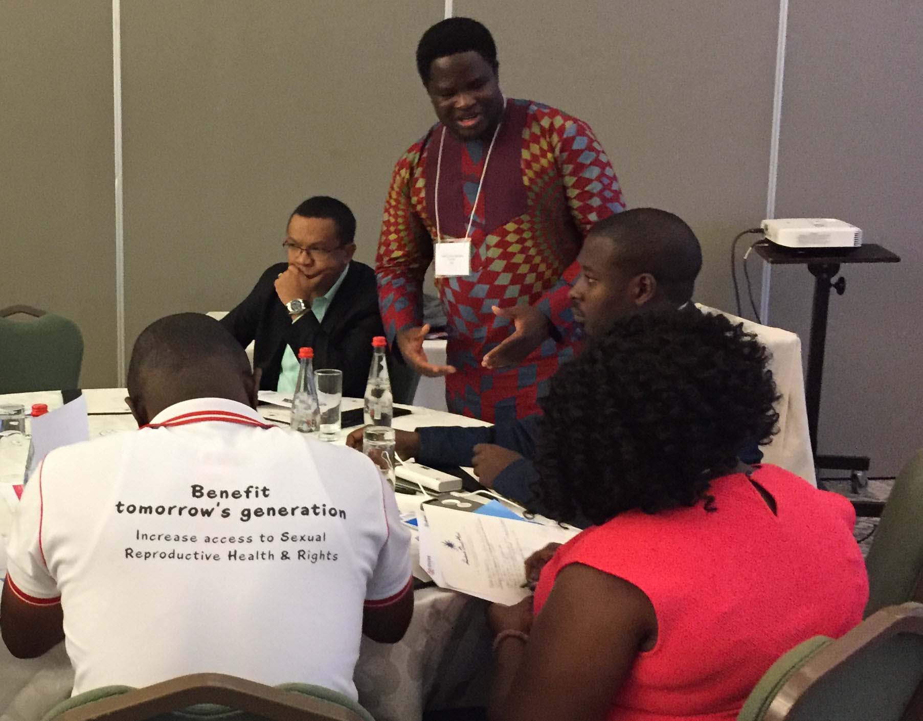 A small group of people sit around a table at a workshop