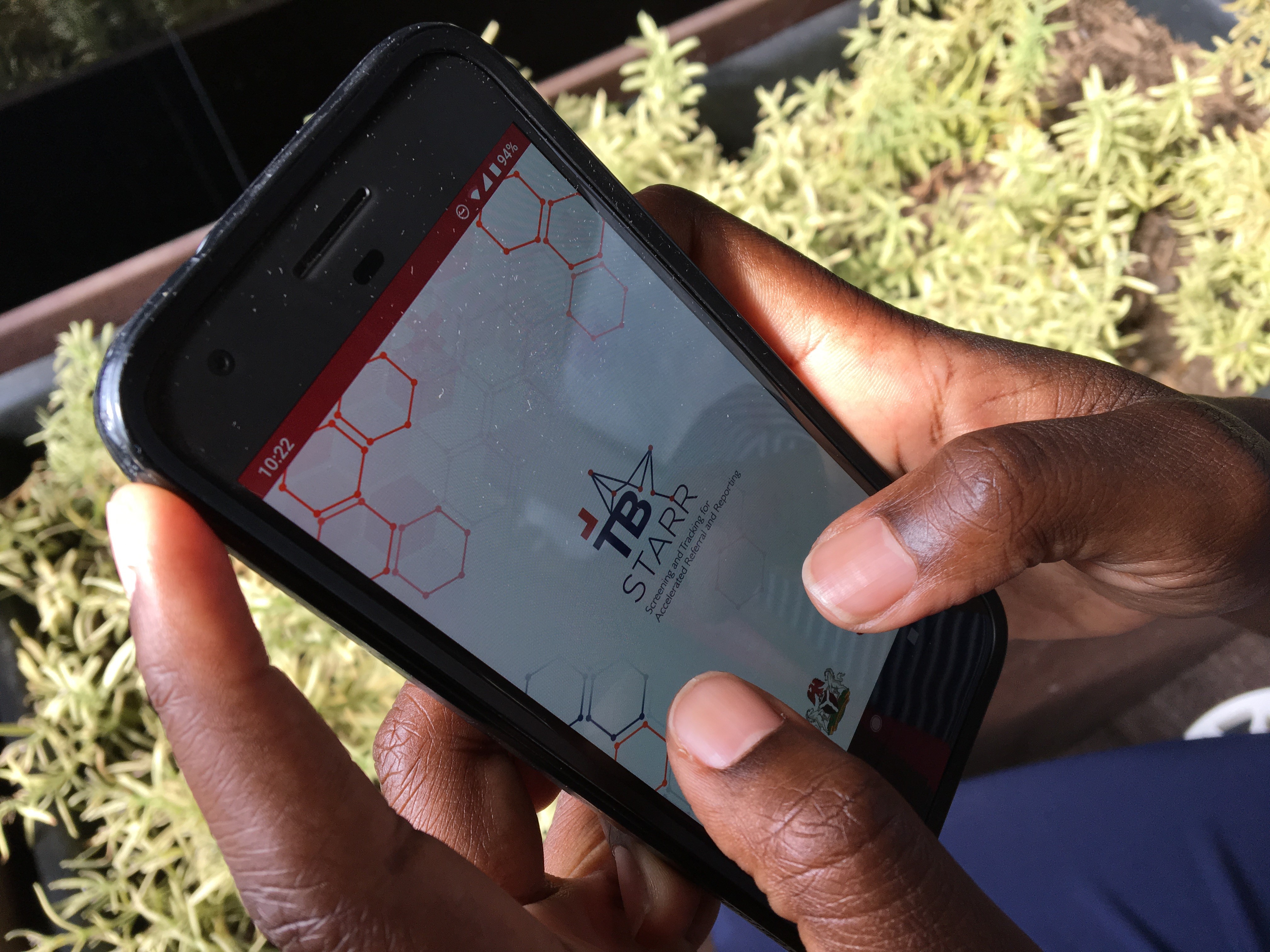 Person holding a phone with the TB STARR app on the screen.